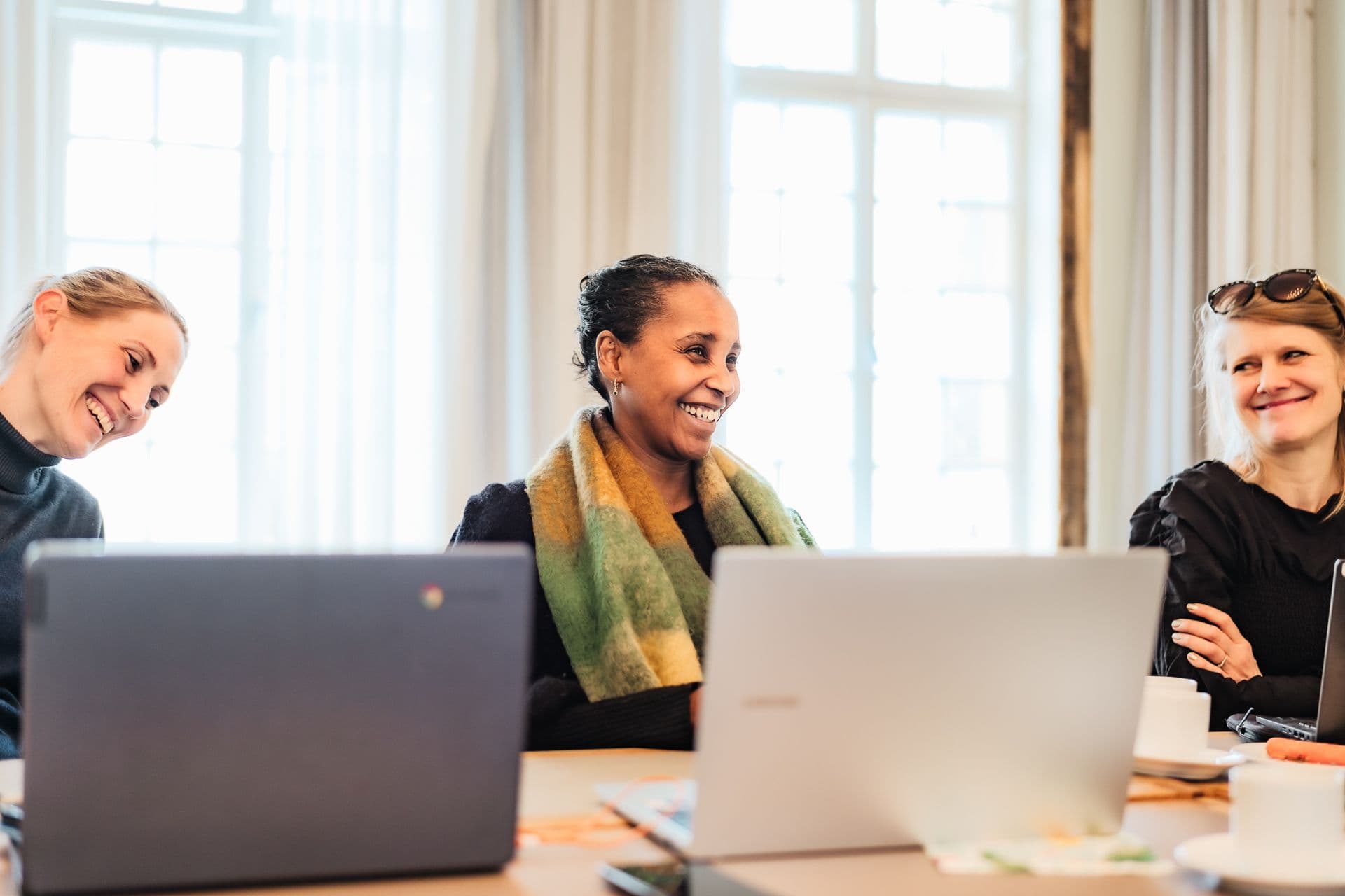 Tre damer i et møterom sammen